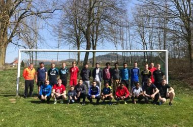Mehrere Menschen vor einem Fußball Tor die freuen sich